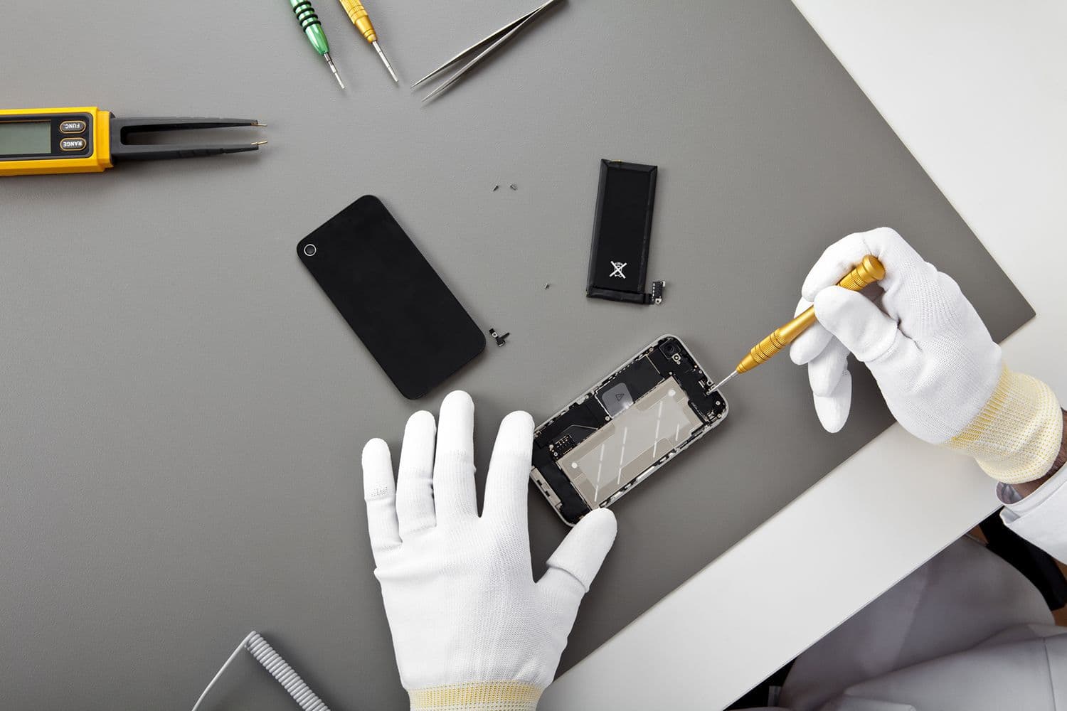 Technician replacing a phone screen at the FIXITT repair bench